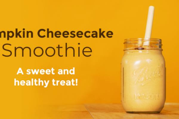 A Pumpkin Cheesecake Smoothie in a glass jar with a straw. The words "Pumpkin Cheesecake Smoothie, a sweet and healthy treat!" on it.